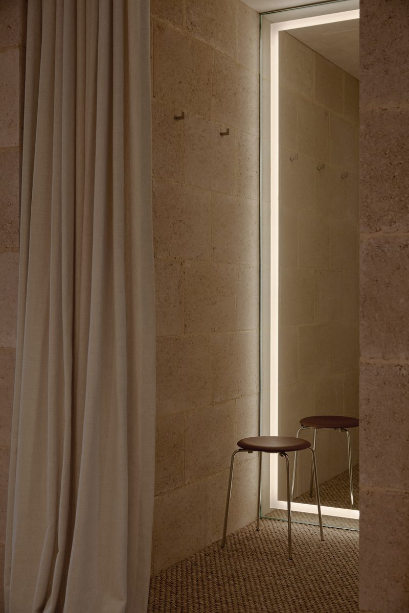 Linen curtain beside a timber stool in soft light