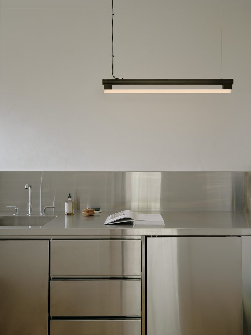 Stainless steel kitchen with a black pendant light