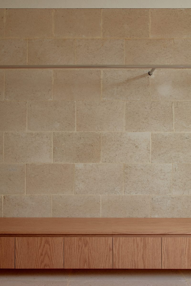 Travertine block wall above a timber bench
